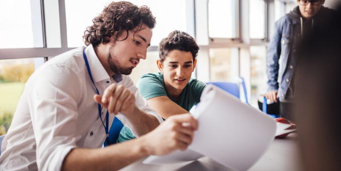 Schüler besprechen ihre Bewerbungsunterlagen mit einem Experten.