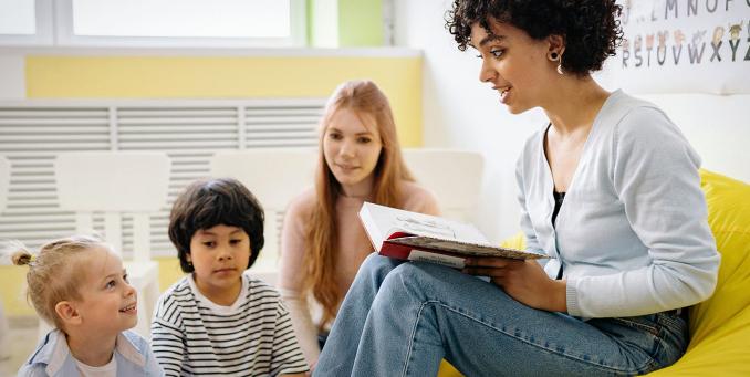 Dein Engagement in sozialen Einrichtungen. Eine Person liest Kindern vor.